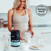 Woman in a beige tank top preparing a smoothie with Switch Nutrition Protein, bananas, and a milk bottle, with a '30-day money back guarantee' badge.