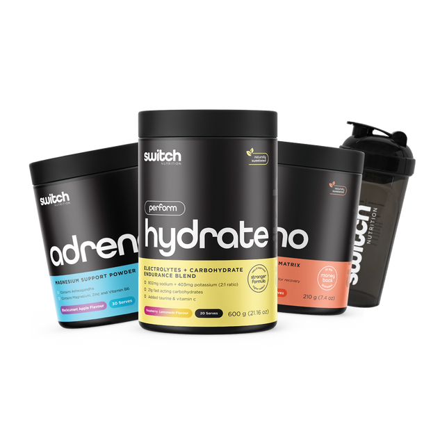 A group of Switch Nutrition supplements—including Adrenal Switch (magnesium support powder), Hydrate Perform (electrolytes + carbohydrate blend), and Amino Switch (EAA matrix)—arranged with a black Switch-branded shaker cup.