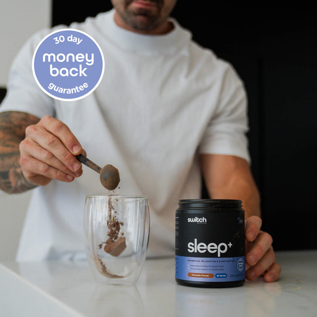 Man in a white shirt scooping Sleep+ powder into a glass, with a 30-day money-back guarantee badge displayed on the image.